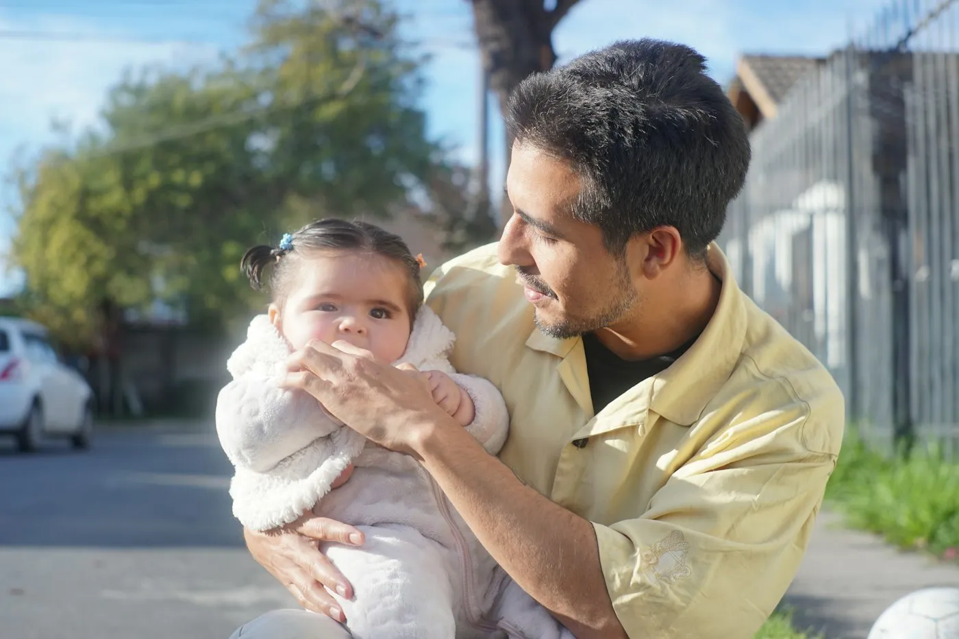 A father holding his baby in the sunlight